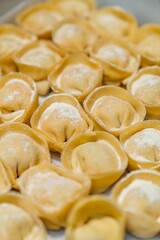 Raw stuffed homemade pasta cappelletti on a tray. Close up.