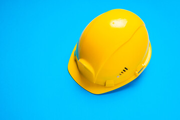 Yellow construction safety hard hat on blue background