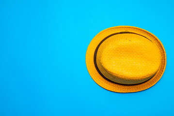 Top view of straw hat over blue background. Flat lay top-down compositiont. Minimalist flat lay photo of straw hat with copy space.