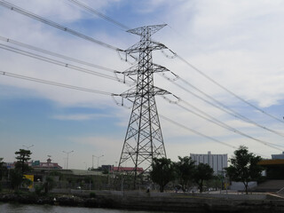 The view of the electric power tower, subtransmission line tower, beside the river in Bangkok, Thailand.