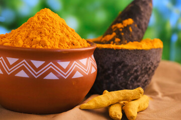 Dry turmeric powder (curcuma longa linn) stone mortar, traditional Indian kitchen Masala for curry,...