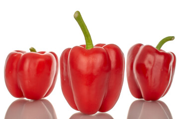 Three red bell peppers, macro, isolated on white background.