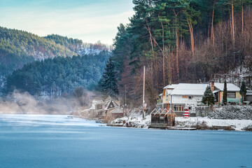 Winter landscape of a frozen lake with fishing houses.