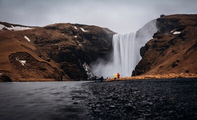cascading waterfall amidst a winter wonderland of snow and grass, in Reykjavik, Iceland