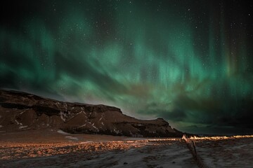 Obraz na płótnie Canvas aurora borealis in the night sky above Reykjavik, Iceland, with stars twinkling in the background