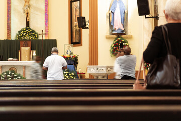 Fototapeta na wymiar Unrecognizable people inside the San Isidro Cathedral praying.