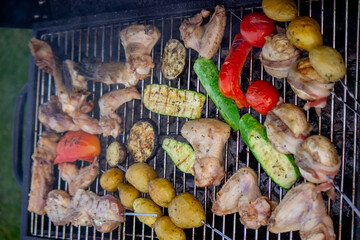a man is grilling vegetables and meat. Selective focus.