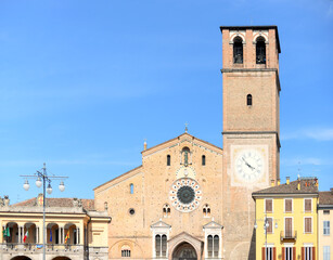 Obraz premium Roman catholic cathedral (also called duomo or basilica) with typical houses next to it against blue sky in Lodi, Lombardy, Italy