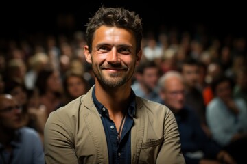 Fototapeta premium A man is asking a question to a speaker during a Q&A session at an international technical conference in a darkened auditorium. the young expert shows off