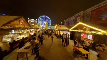Ferris wheel, street fair on Kotraktova Square. Evening Kyiv. Holiday season Kyiv December Festive Illumination. Christmas market street food, street market in evening New Years holidays