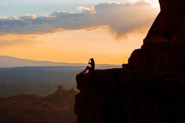  Young hiker woman on the edge of a cliff at Cathedral Rock in Sedona, Arizona. View from Scenic Cathedral Rock in Sedona with blue sky in Arizona - 628947888