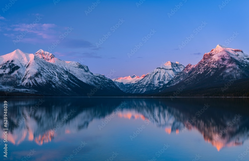 Sticker Early morning sunrise illuminating serene waters of Lake McDonald, Glacier National Park, Montana