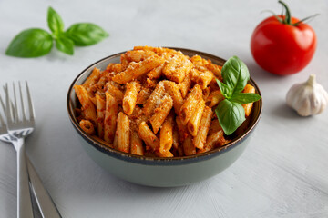Homemade Tomato Pesto Pasta with Cheese and Basil in a Bowl, side view.