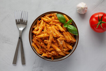 Homemade Tomato Pesto Pasta with Cheese and Basil in a Bowl, top view. Flat lay, overhead, from above.