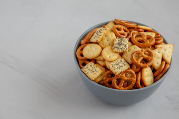 Homemade Party Snack Mix with Crackers and Pretzels in a Bowl, side view. Copy space.