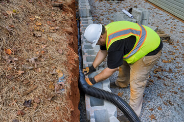 Construction project on proper installation of drainage pipe for rainwater in retaining wall.