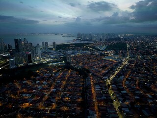 Evening cityscape featuring illuminated buildings and a tranquil ocean. Panama City.