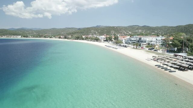 Aerial scene of Toroni Beach with houses coastline with cloudy sky in Greece