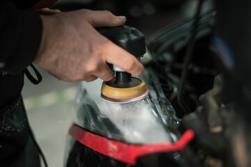 Person is professionally detailing a vehicle's trunk compartment using a polishing machine