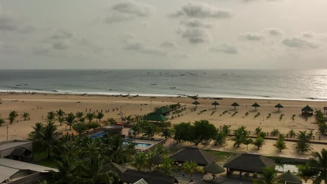 Aerial video of buildings and palm trees on the sea shore in Accra, Ghana