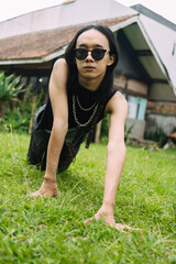 an Asian woman with sunglasses and a black shirt posing and crawling