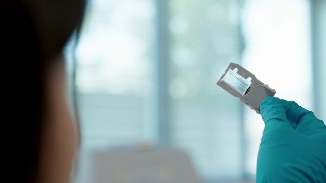 Laboratory technologist holding a genome cell chip in the lab for research
