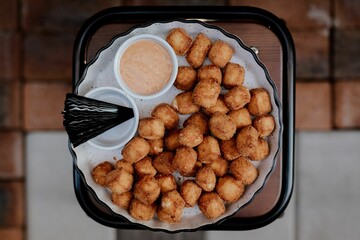 White plate with fried cheese balls and source
