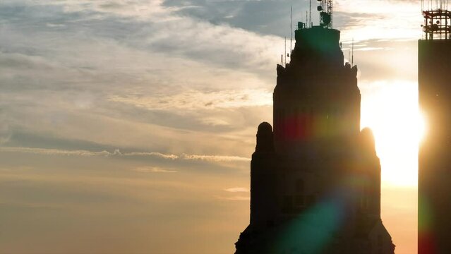 Aerial video darkened silhouette top of LeVeque Tower at sunrise panning toward Rhodes Tower