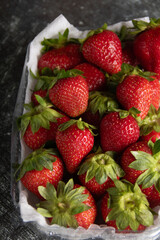 photo of juicy, fresh, ripe strawberries in a plastic container