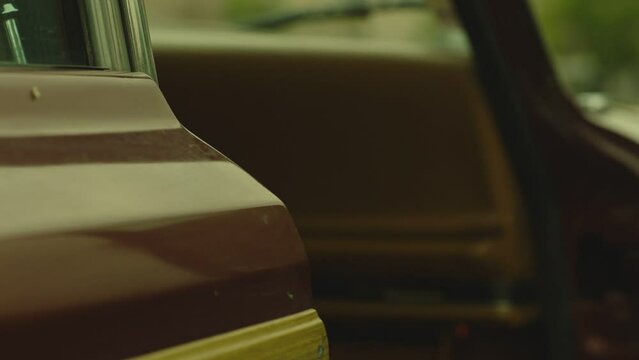 Close-up of car door with old chrome handle. Man's hand with black gloves closing or opening door . Man opens the driver's seat door . American vintage suv Jeep Wagoneer . Concept of robbery or theft