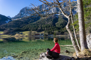 Urlaub in Bayern: der magische Hintersee bei Ramsau, Berchtesgaden mit schneebedeckten Bergen und Wald - Frau, Wanderin genießt die Ruhe und den Ausblick