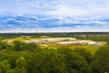 Panorama miasta Żagań wykonana z dużej wysokości z użyciem drona. Na pierwszym planie widać budynki w strefie ekonomicznej przy ulicy Asnyka, na drugim planie widać odległe centrum miasta. - 628977862