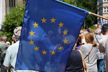 Big flag of European Union, in background people in soft focus