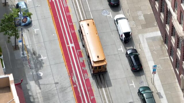 Downward shot in aerial following trolly in downtown San Francisco