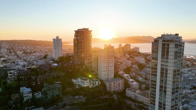 Sunset in downtown area with skyscrapers and San Francisco Bay and mountains