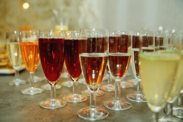 A lot of wine glasses with different types of wine on the table at the ceremony. Selective focus. Close-up.