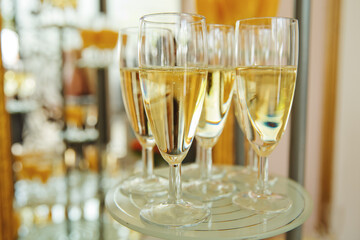A lot of wine glasses with champagne on the table at the ceremony. Selective focus. Close-up.