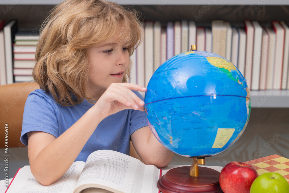 Poster cute pupil looking at globe in library at the elementary school. school child. kid boy from elementa