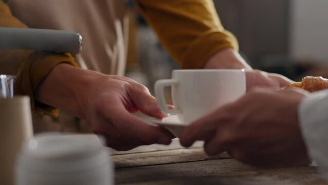 Bar, professional barista serves coffee order to customer in coffee bar the bartender in the process of preparing at the workplace follows the modern principles of morning drinks, receiving the parcel