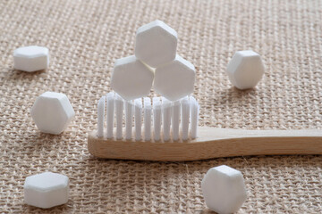 Obraz na płótnie Canvas White solid toothpaste tablet with bamboo toothbrush