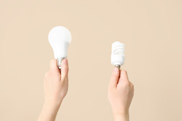 Woman with light bulbs on beige background