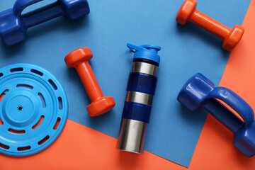 Composition with bottle of water, dumbbells and frisbee disk on color background
