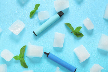 Electronic cigarettes with mint and ice cubes on blue background