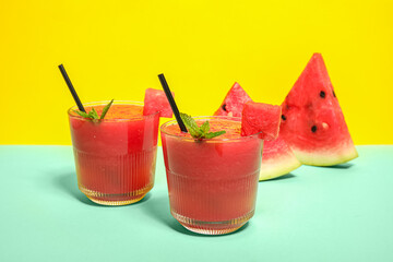 Glasses of tasty watermelon juice with mint on colorful background