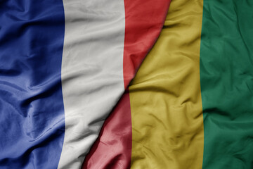 big waving realistic national colorful flag of france and national flag of guinea .