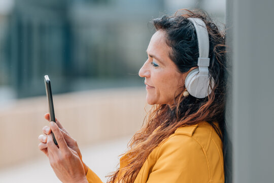 middle-aged woman with mobile phone and headphones