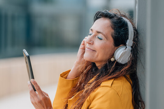 middle-aged woman with mobile phone and headphones