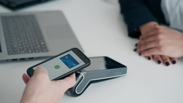  Video close up of hands charging with dataphone and paying with smartphone