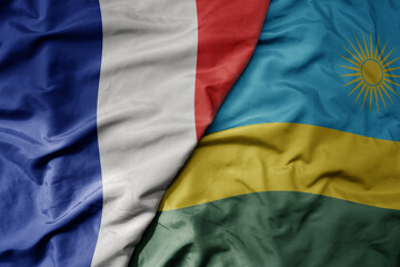 big waving realistic national colorful flag of france and national flag of rwanda .