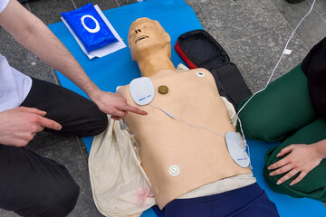 First-aider practicing chest compressions - obrazy, fototapety, plakaty